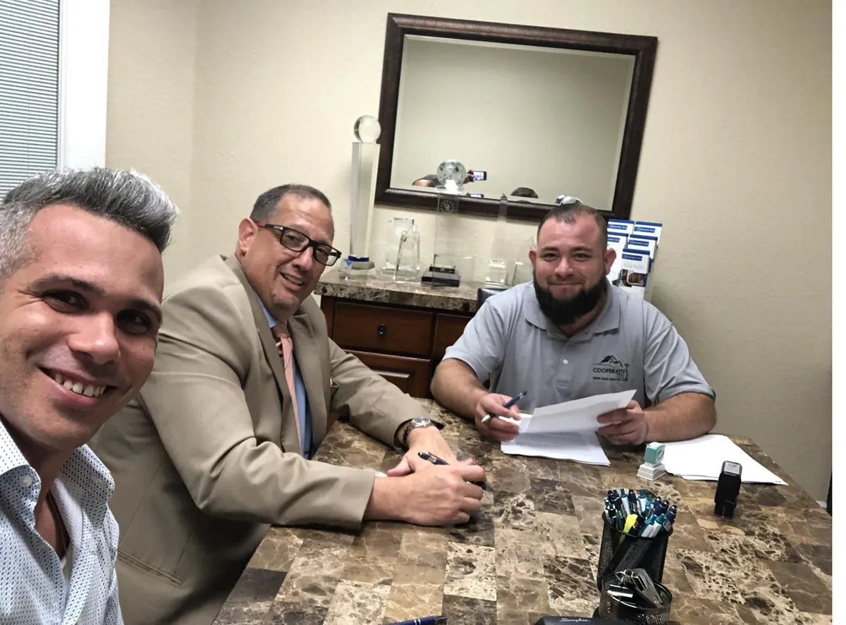 Reunión de cierre en mesa de firma con clientes